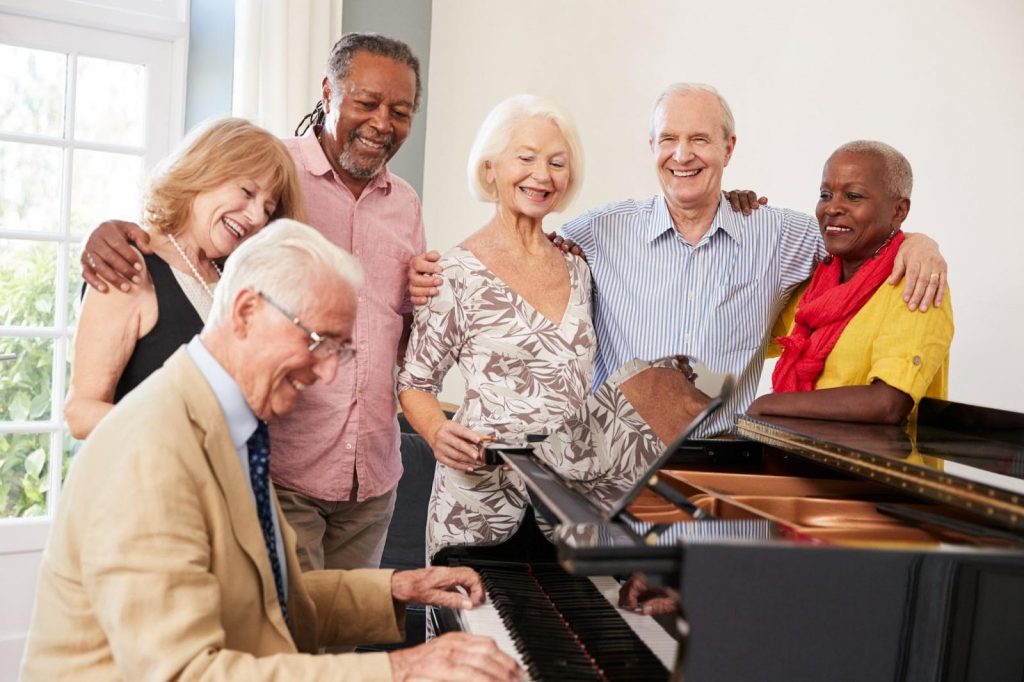 Group of seniors around a piano