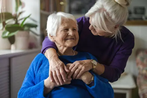 Woman Embracing and Supporting Senior Woman