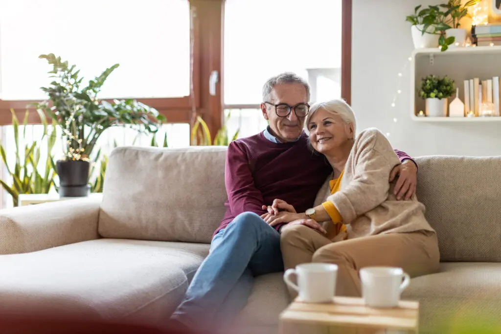 Senior couple hugging on couch