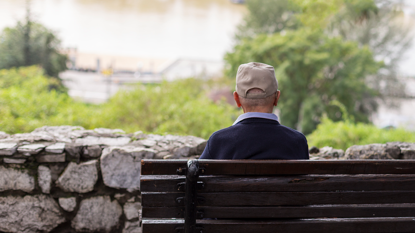 Senior man, sitting on a bench in a park