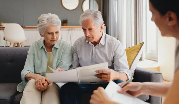 a senior couple looking over documents with their financial advisor