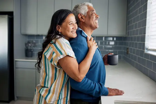 a senior couple hugging in their kitchen