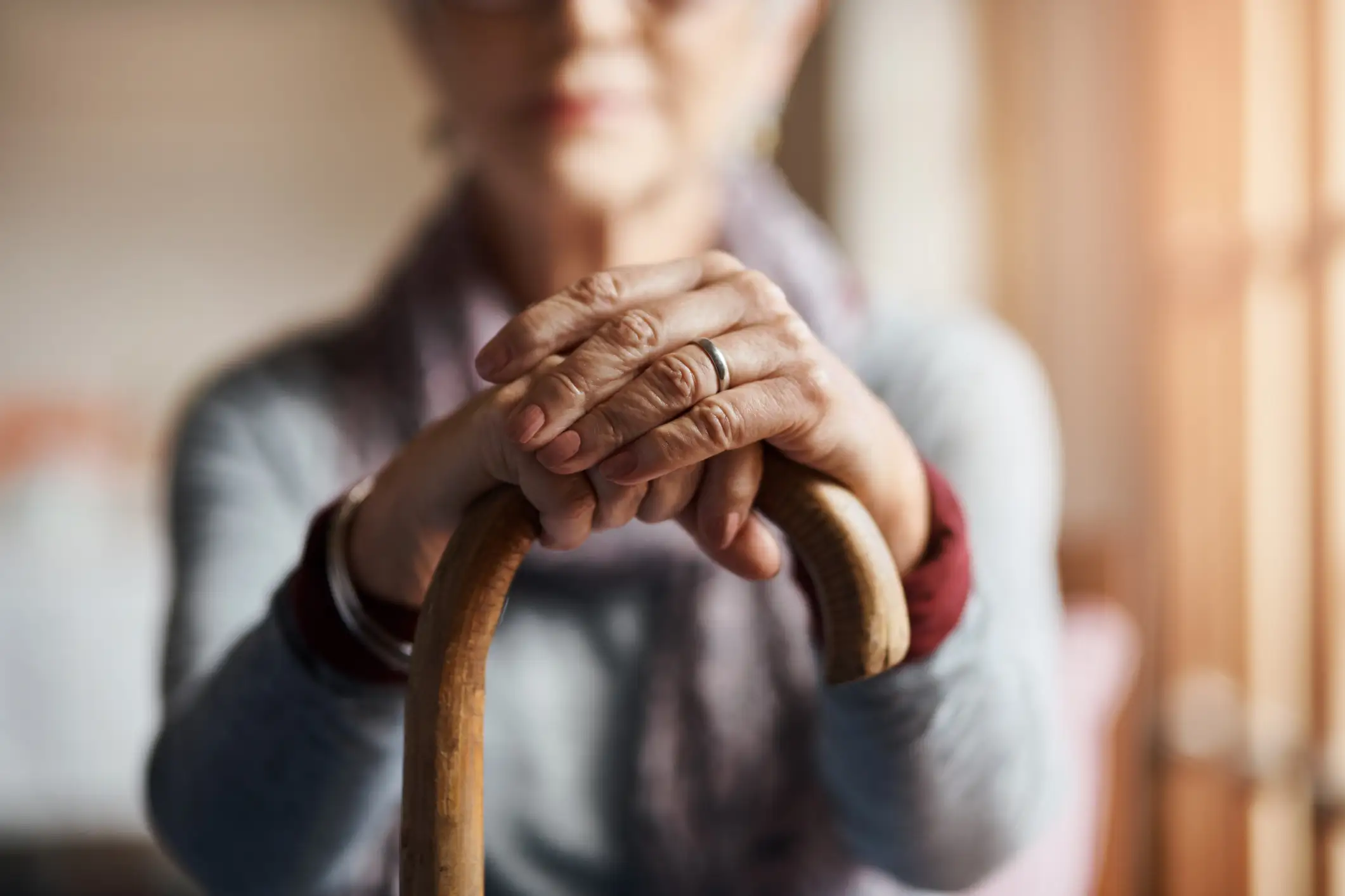 Close-up of a senior woman resting on her cane