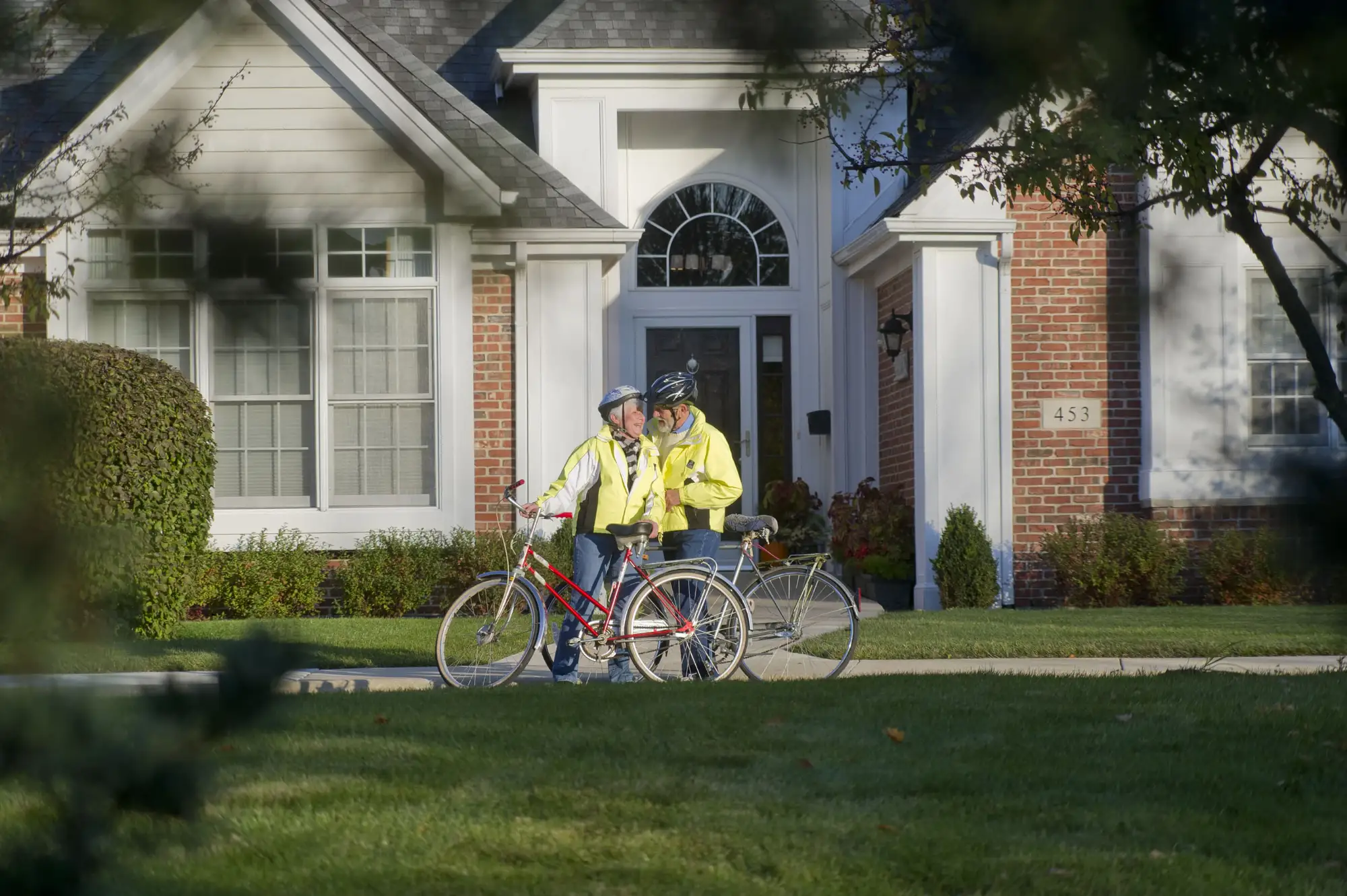 A senior couple bike riding outside the Townhomes at Wyndemere