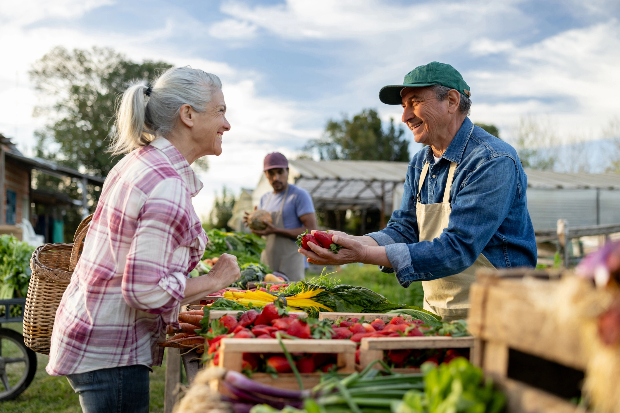 Two active senior residents of Wyndemere at a local produce market holding and looking at strawberries Wheaton, Illinois. 