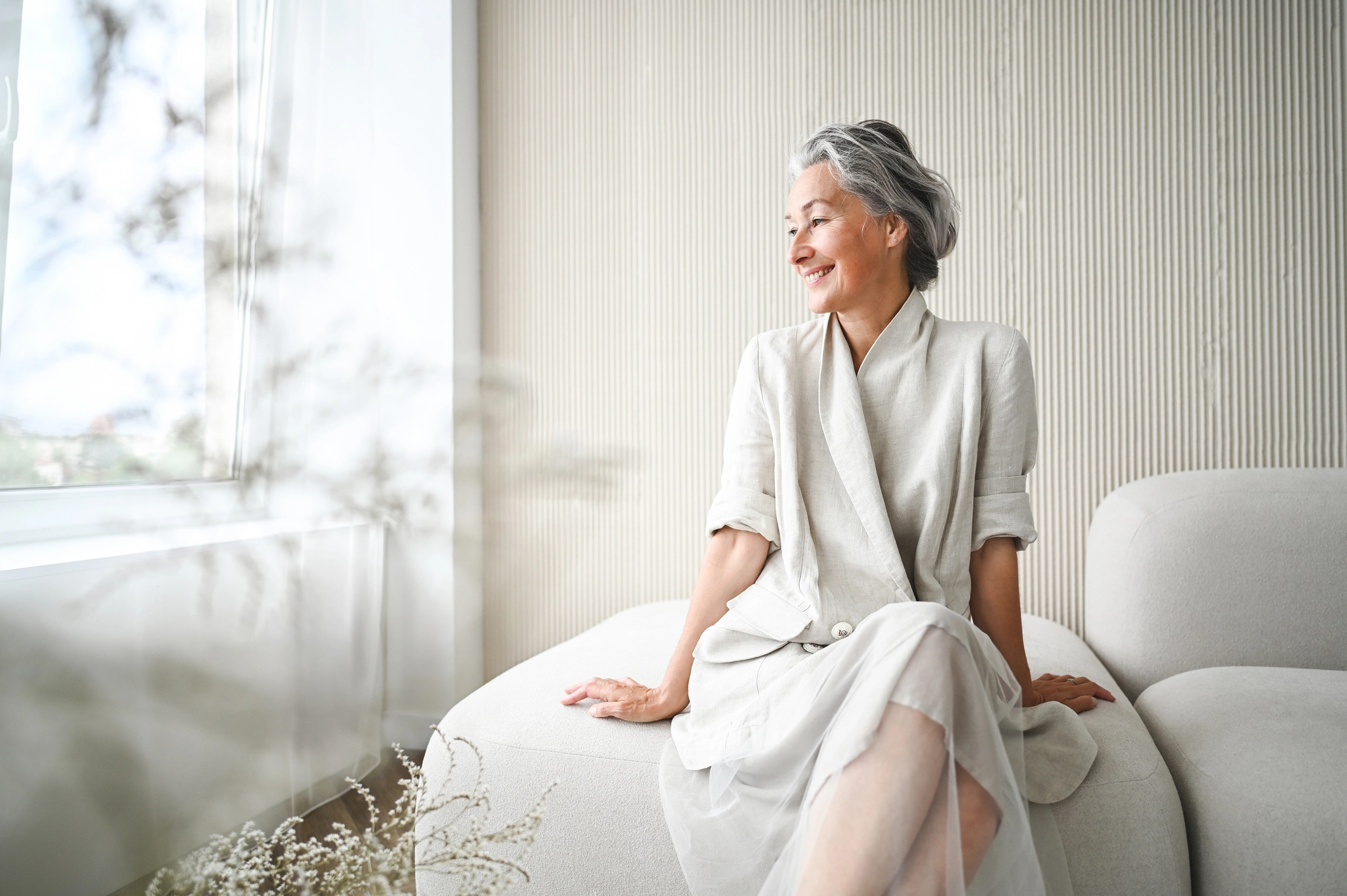 senior woman smiling in a senior community apartment because she compared the cost of senior living vs. home ownership at Wyndemere in Wheaton, IL.