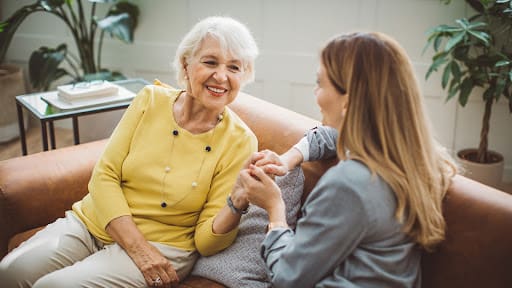 senior woman on the couch with her caregiver